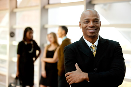 stock-photo-a-happy-black-business-man-with-people-in-the-background-47419153