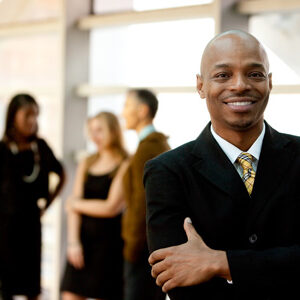 stock-photo-a-happy-black-business-man-with-people-in-the-background-47419153